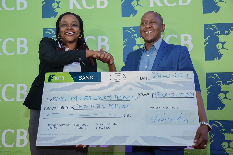   KCB Marketing and Communications Director, Angela Mwirigi (left) hands over a dummy cheque of Ksh 25,000,000 to KMSF Director and Chairman of the Board, Phineas Kimathi (right) during the KCB Rally sponsorship press briefing at the Heart of Kencom.PHOTO/SPN