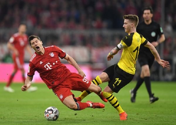 In this file photo taken on April 6, 2019 Dortmund's midfielder Marco Reus (R) fouls Bayern Munich's Polish striker Robert Lewandowski during the German first division Bundesliga football match FC Bayern Munich vs Borussia Dortmund in the stadium in Munich, southern Germany. - Bayern Munich face rivals Borussia Dortmund in the Supercup, a one-off football match in Germany that features the winners of the Bundesliga championship and the DFB-Pokal on August 3, 2019.PHOTO/ GETTY IMAGES