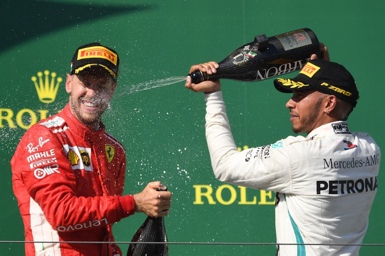  In this file photo taken on July 29, 2018, winner Mercedes' British driver Lewis Hamilton (R) and second placed Ferrari's German driver Sebastian Vettel celebrate on the podium as they spray champagne after the Formula One Hungarian Grand Prix at the Hungaroring circuit in Mogyorod near Budapest. Sebastian Vettel is desperate to close the championship gap on Lewis Hamilton at the Singapore Grand Prix this weekend and erase Ferrari's painful memories from 12 months ago. PHOTO/AFP