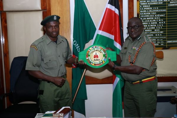 Rayton 'Boom Boom' Okwiri when he presented the coveted ABU belt to Kenya Prisons Service Commissioner General Wycliffe Ogallo in Nairobi on June 27, 2019. PHOTO/ KPS