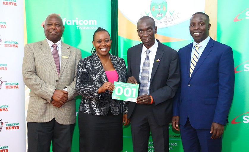 Safaricom Brand Assets Manager, Mishi Wambiji presents a race number to the Berlin World Marathon record holder Eliud Kipchoge, for Isaiah Kiplagat Ndalat Cross Country Race on October 4, 2018.PHOTO/SPN