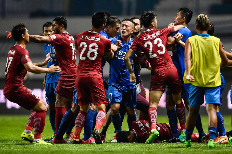 A brawl erupting between Shanghai SIPG players (red) and Guangzhou R&F players, as Shanghai's Oscar lies on the ground, during their Chinese Super League football match in Guangzhou in China's southern Guangdong province. PHOTO/AFP