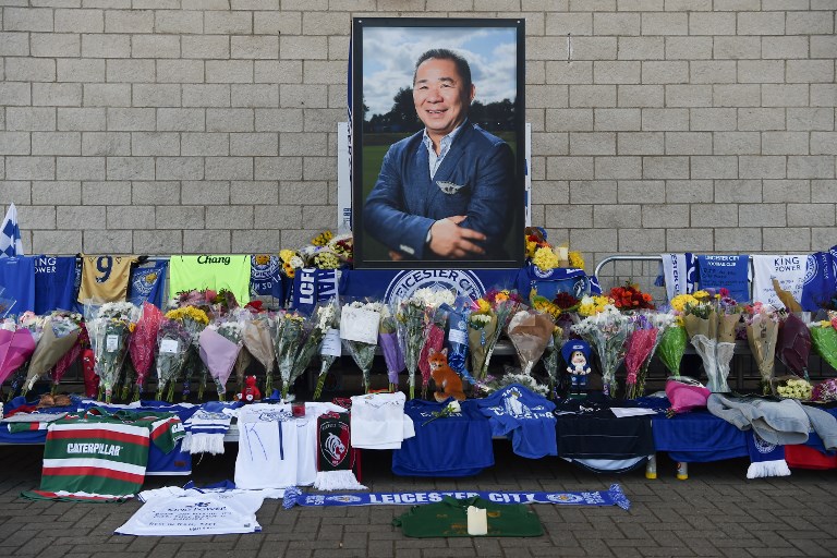 A portrait of Leicester City Football Club's Thai chairman Vichai Srivaddhanaprabha, who died in a helicopter crash at the club's stadium, is seen amid flowers and tributes outside the King Power Stadium in Leicester, eastern England, on October 29, 2018. Leicester City's chairman Vichai Srivaddhanaprabha was among five people killed when his helicopter crashed and burst into flames in the Premier League side's stadium car park moments after taking off from the pitch, the club said on October 28. A stream of fans already fearing the worst had laid out flowers, football scarves and Buddhist prayers outside the club's King Power stadium after Saturday's accident in tribute to the Thai billionaire boss -- the man they credit for an against-all-odds Premier League victory in 2016. PHOTO/AFP