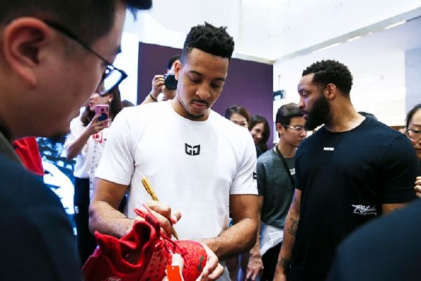 American basketball player Christian James McCollum signs autograph on football shoes for fans during his China tour on June 14, 2019 in Shijiazhuang, Hebei Province of China.PHOTO/ GETTY IMAGES