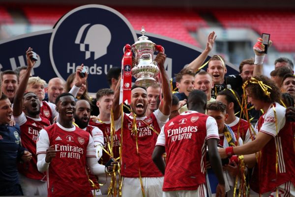 Arsenal's Gabonese striker Pierre-Emerick Aubameyang (C) holds the winner's trophy as the team celebrates victory after the English FA Cup final football match between Arsenal and Chelsea at Wembley Stadium in London, on August 1, 2020. Arsenal won the match 2-1. PHOTO | AFP