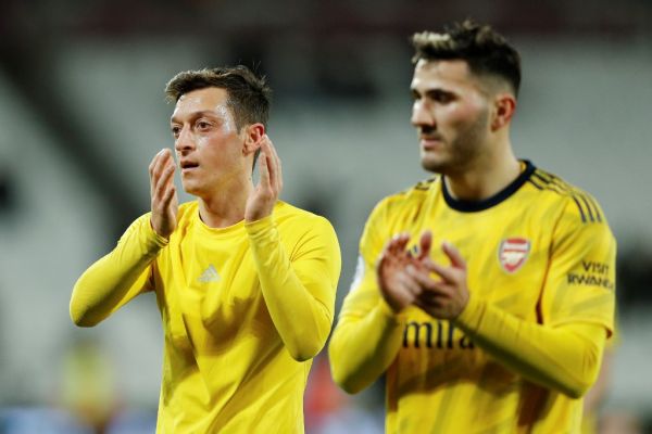 Arsenal's German midfielder Mesut Ozil (L) applauds the fans following the English Premier League football match between West Ham United and Arsenal at The London Stadium, in east London on December 9, 2019. PHOTO | AFP