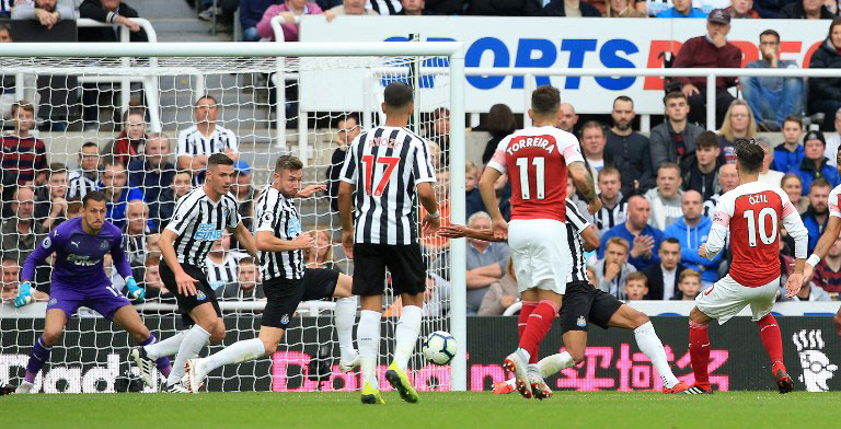 Arsenal's German midfielder Mesut Ozil (R) scores his team's second goal during the English Premier League football match between Newcastle United and Arsenal at St James' Park in Newcastle-upon-Tyne, north east England on September 15, 2018. PHOTO/AFP