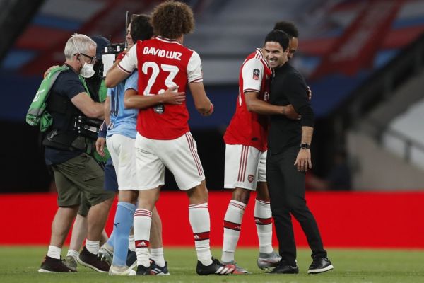 Arsenal's Spanish head coach Mikel Arteta (R) embraces Arsenal's Gabonese striker Pierre-Emerick Aubameyang (2R) at the end of the English FA Cup semi-final football match between Arsenal and Manchester City at Wembley Stadium in London, on July 18, 2020. PHOTO | AFP