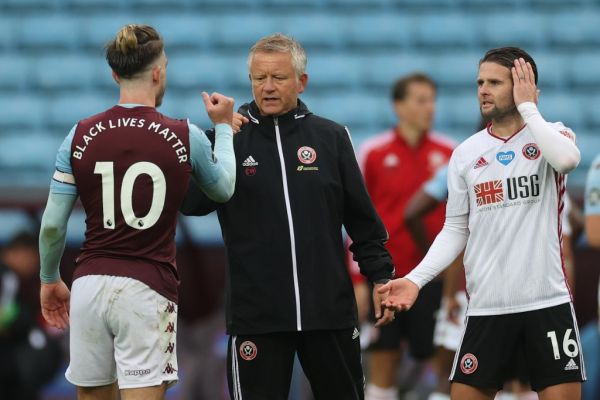 Aston Villa's English midfielder Jack Grealish (L), Sheffield United's English manager Chris Wilder (2nd L) and Sheffield United's English-born Northern Irish midfielder Oliver Norwood (3rd L) tap hands after the English Premier League football match between Aston Villa and Sheffield United at Villa Park in Birmingham, central England on June 17, 2020. PHOTO | AFP