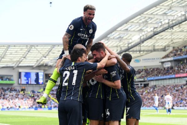 Aymeric Laporte of Manchester City celebrates with teammates after scoring his team's second goal as Kyle Walker of Manchester City jumps on top during the Premier League match between Brighton & Hove Albion and Manchester City at American Express Community Stadium on May 12, 2019 in Brighton, United Kingdom. PHOTO/ GETTY IMAGES