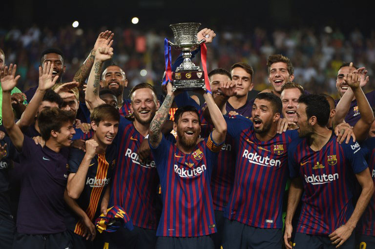Barcelona's Argentinian forward Lionel Messi (C) carries the cup as they celebrate at the end of the Spanish Super Cup final between Sevilla FC and FC Barcelona at Ibn Batouta Stadium in the Moroccan city of Tangiers on August 12, 2018. Barcelona defeated Sevilla 2-1 to win the Spanish Super Cup. PHOTO/AFP