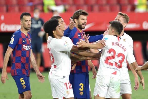 Barcelona's Spanish defender Gerard Pique (C) argues with Sevilla's Spanish defender Sergio Reguilon (R) during the Spanish league football match between Sevilla FC and FC Barcelona at the Ramon Sanchez Pizjuan stadium in Seville on June 19, 2020. PHOTO | AFP