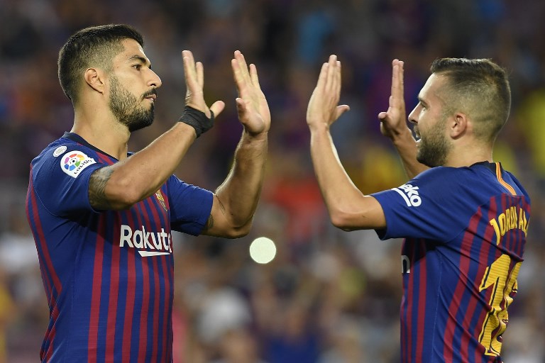 Barcelona's Spanish defender Jordi Alba (R) congratulates Barcelona's Uruguayan forward Luis Suarez for scoring their eighth goal during the Spanish league football match between FC Barcelona and SD Huesca at the Camp Nou stadium in Barcelona on September 2, 2018. PHOTO/AFP