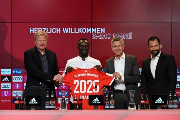 Bayern Munich's Senegalese new forward Sadio Mane (2L) with his jersey poses next to Bayern Munich CEO Oliver Kahn (L), President Herbert Hainer (2ndR) and Sporting Director Hasan Salihamidzic during a press conference after he signed a three-year deal with German first division football club FC Bayern Munich, in Munich, southern Germany, on June 22, 2022. PHOTO | AFP