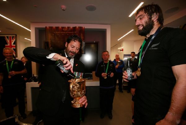 Bill Henry 'Willie' Apiata VC pours a beer into the Webb Ellis Cup with Sam Whitelock of New Zealand watching on as the New Zealand team celebrate in the dressing room after the 2015 Rugby World Cup Final match between New Zealand and Australia at Twickenham Stadium on October 31, 2015 in London, United Kingdom.PHOTO/GETTY IMAGES