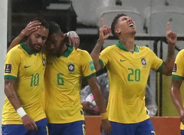 Brazil's Roberto Firmino (R) celebrates next to teammates Neymar (L) and Renan Lodi after scoring against Bolivia during their 2022 FIFA World Cup South American qualifier football match at the Neo Quimica Arena, also known as Itaquerao, in Sao Paulo, Brazil, on October 9, 2020, amid the COVID-19 novel coronavirus pandemic. PHOTO | AFP