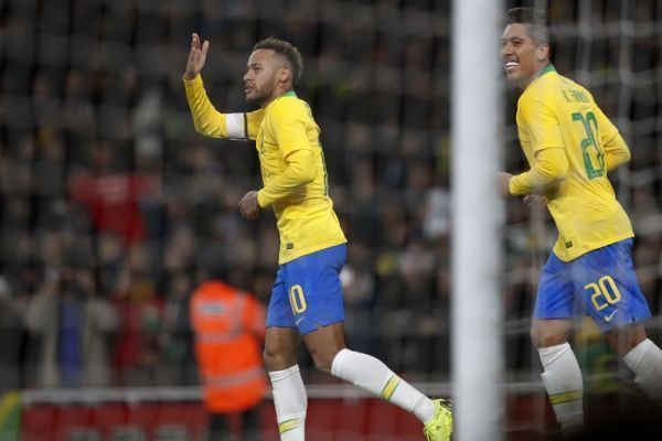 Brazil's striker Neymar (L) celebrates with Brazil's striker Roberto Firmino (R) after scoring the opening goal from the penalty spot during the international friendly football match between Brazil and Uruguay at The Emirates Stadium in London on November 16, 2018. PHOTO/AF