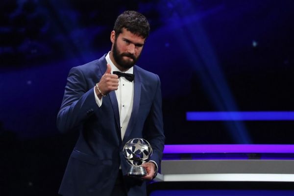 Brazilian goalkeeper Alisson Becker poses with his trophy of UEFA Goalkeeper of the Year during the UEFA Champions League football group stage draw ceremony in Monaco on August 29, 2019. PHOTO | AFP