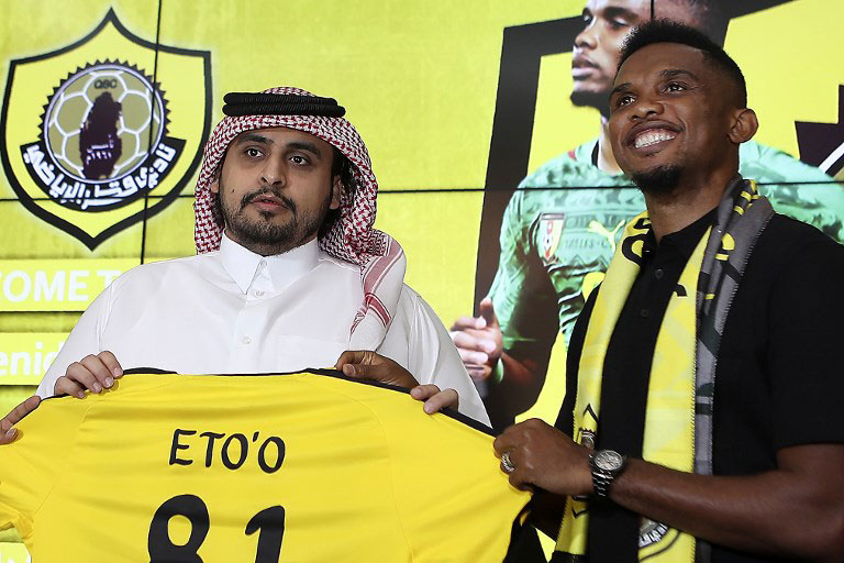 Cameroonian forward Samuel Eto'o poses with his jersey as he attends a press conference after signing a one year contract to play for Qatar Sports Club football team, next to the club's president Sheikh Jassim bin Hamad bin Nasser al-Thani (L), in Doha on August 14, 2018. PHOTO/AFP