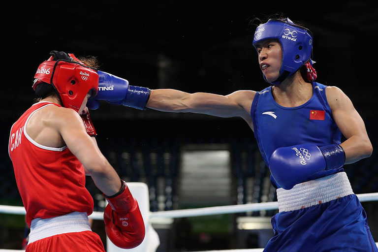 Cancan Ren of People's Republic of China throws a right on Mandy Bujold of Canada in the Women's Boxing Fly Weight (48-51kg) Quarterfinal 2 on Day 11 of the Rio 2016 Olympic Games at Riocentro on August 16, 2016 in Rio de Janeiro, Brazil. PHOTO/IOC