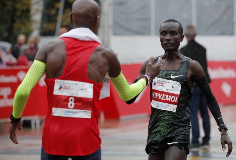 Chicago Marathon winner Mo Farah of Britain (L) greets Kenneth Kipkemoi of Kenya after he crosses the finish line in fourth place in Chicago, on October 7, 2018. PHOTO/AFP
