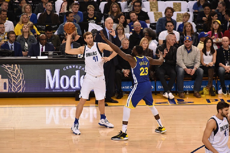 Dirk Nowitzki #41 of the Dallas Mavericks looks to pass against Draymond Green #23 of the Golden State Warriors on March 23, 2019 at ORACLE Arena in Oakland, California. PHOTO/GettyImages