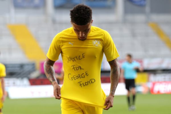 Dortmund's English midfielder Jadon Sancho shows a "Justice for George Floyd" shirt as he celebrates after scoring his team's second goal during the German first division Bundesliga football match SC Paderborn 07 and Borussia Dortmund at Benteler Arena in Paderborn on May 31, 2020. PHOTO | AFP
