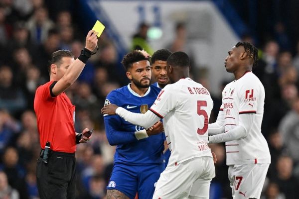 Dutch referee Danny Makkelie (L) gives a yellow card to AC Milan's Senegalese defender Fode Ballo-Toure (2nd R) during the UEFA Champions League Group E football match between Chelsea and AC Milan at Stamford Bridge in London on October 5, 2022. PHOTO | AFP