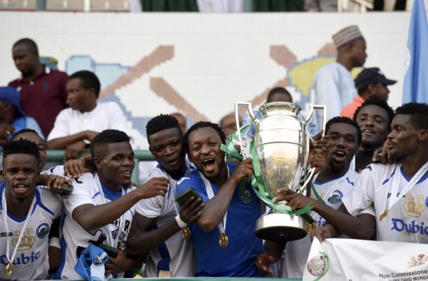 Enyimba players celebrate with Federation Cup at the Teslim Balogun Stadium in Lagos on November 23, 2014. Two-time African champions Enyimba on Sunday retained the Nigeria FA Cup after beating Dolphins 2-1 at the Teslim Balogun Stadium in Lagos. It was Enyimba's fourth cup triumph after they also won in 2005, 2009 and 2013. However, the Aba club will represent Nigeria in next year's CAF Champions League after they finished as runners-up in the league, while beaten finalists Dolphins will feature in the CAF Confederation Cup. PHOTO | AFP