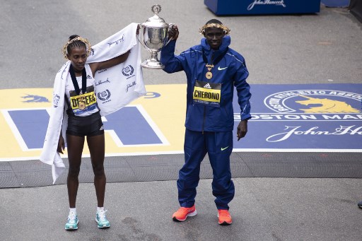 Ethopian Worknesh Degefa(L), and Kenyan Lawrence Cherono, celebrate together after they won the Women's Elite, and Men's Elite races respectfully at the 123rd Boston Marathon on April 15, 2019 in Boston, Massachusetts. PHOTO/AFP