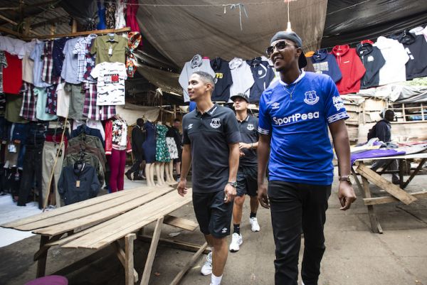 Everton FC ambassador Steven Pienaar (left) and local dancehall star Kevin 'Love Child' Wyre (right) walk through stalls in Nairobi on Friday, July 5, 2019. Behind them is Blues retired hero Leon Osman. PHOTO/SPN