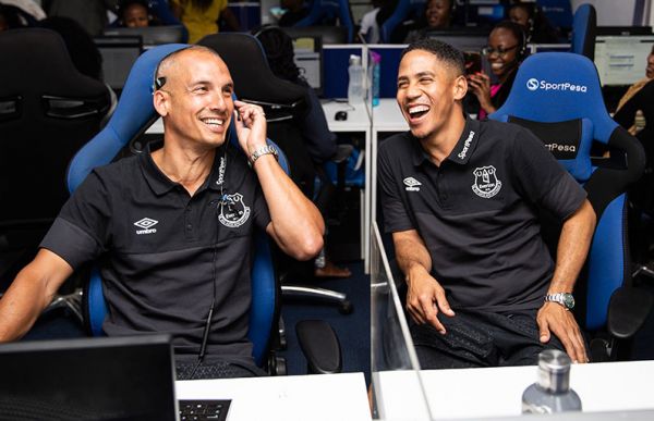Everton hero Leon Osman (left) tries his hand as a SportPesa Customer Service operator as former teammate Steven Pienaar cheers on when the retired stars paid a visit to the technology and entertainment business headquarters in Nairobi on Thursday, July 5, 2019. PHOTO/SPN