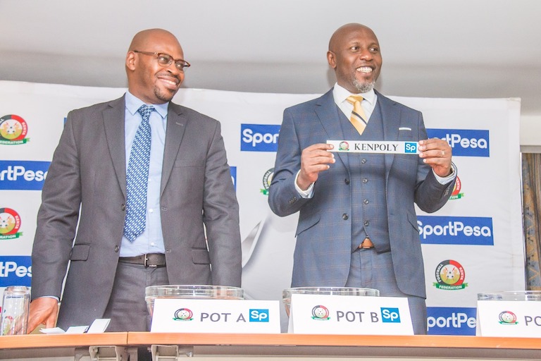 Football Kenya Federation chief executive, Robert Muthomi (left) watches on as SportPesa Chief Marketing Officer, Kelvin Twissa, pulls Kenpoly out of the pot to play Gor Mahia during the launch and draw of the 2019 FKF SportPesa Shield Cup tournament in Nairobi on March 7, 2019. PHOTO/SPN