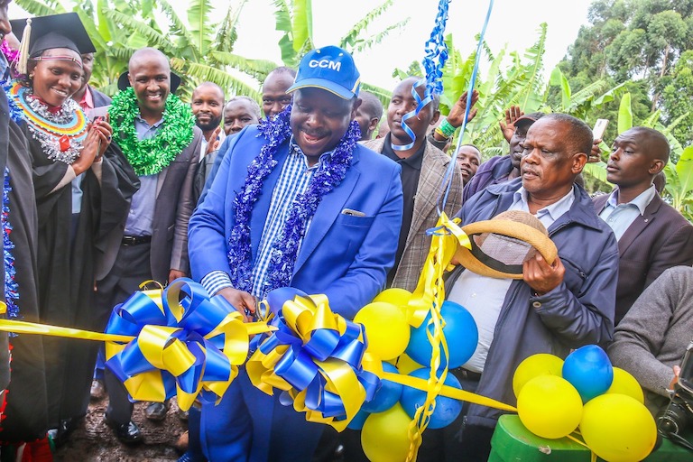 Former Bomet County Governor, Isaac Ruto (in blue) cuts the tape to officially open the new house belonging to SportPesa Mega Jackpot winner, Cosmas Korir in Litein on Tuesday, December 11, 2018. PHOTO/AFP