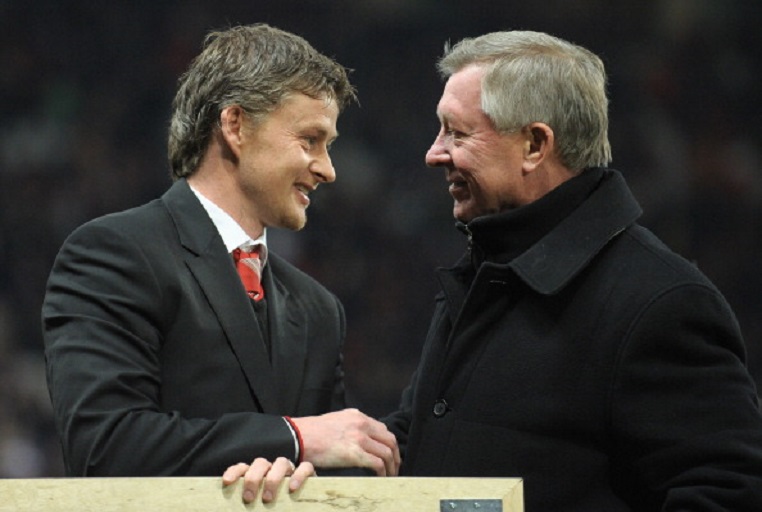 Former Manchester United footballer and reserve team coach, Norweigan Ole Gunner Solskjaer (L) receives a gift of appreciation after 14 years service at the club from manager Sir Alex Ferguson ahead of the English Premier League football match between Manchester United and Arsenal at Old Trafford in Manchester, north-west England on December 13, 2010. Solskjaer has left the clu to become manager of Norweigan team Molde. PHOTO/GettyImages