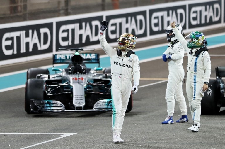 Formula 1 world champion Lewis Hamilton (left) waves to the crowd. PHOTO/File