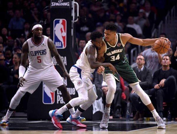 Giannis Antetokounmpo #34 of the Milwaukee Bucks back down Patrick Beverley #21 of the LA Clippers as Montrezl Harrell #5 looks on during the first half at Staples Center on November 06, 2019 in Los Angeles, California. PHOTO | AFP