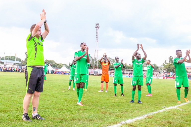 Gor Mahia FC Dylan Kerr and a couple of his players applaud the fans after a recent match. PHOTO/SPN