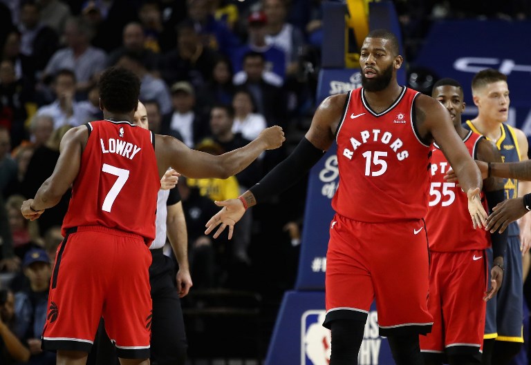 Greg Monroe #15 of the Toronto Raptors is congratulated by Kyle Lowry #7 after he was fouled by the Golden State Warriors at ORACLE Arena on December 12, 2018 in Oakland, California.PHOTO/AFP