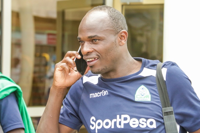 HI, I'M HOME: Gor Mahia FC striker, Dennis Oliech, speaks on his phone after the team landed back in Nairobi on January 24, 2018 following their shock exit from the 2019 SportPesa Super Cup at the hands of Tanzania side, Mbao FC. PHOTO/SPN