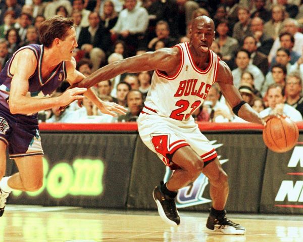 In this file photo taken on June 4, 1997 Chicago Bulls player Michael Jordan sticks out his tongue as he goes past Jeff Hornacek of the Utah Jazz during game two of the NBA Finals at the United Center in Chicago, IL. The immense global success of the documentary "The Last Dance" amid the coronavirus lockdown has boosted sales of collectibles related to NBA icon Michael Jordan, some of which are trading in the hundreds of thousands of dollars. PHOTO | AFP