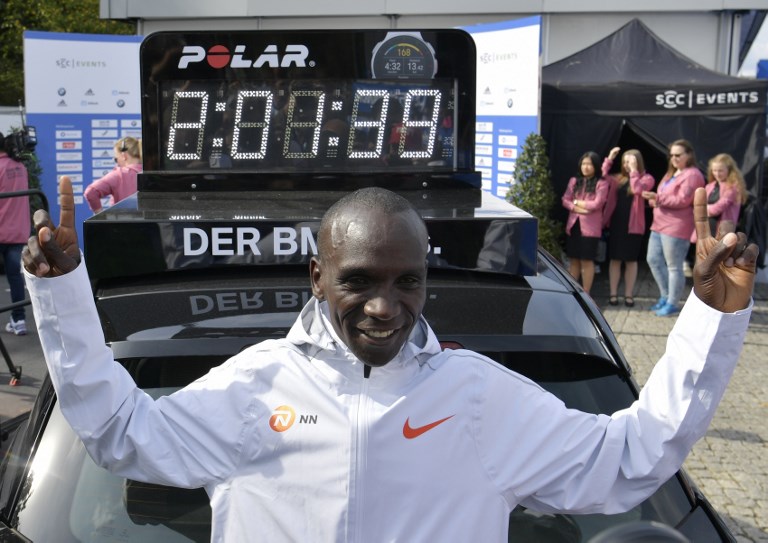 In this file photo taken on September 16, 2018 Kenya's Eliud Kipchoge stands in front of a clock displaying his time after winning the Berlin Marathon setting a new world record with 2h01m39s in Berlin. PHOTO/AFP