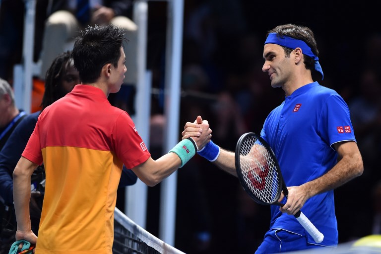 Japan's Kei Nishikori (L) greets Switzerland's Roger Federer after winning their singles round robin match 7-6, 6-3 on day one of the ATP World Tour Finals tennis tournament at the O2 Arena in London on November 11, 2018. PHOTO/AFP