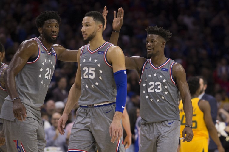 Joel Embiid #21, Ben Simmons #25, and Jimmy Butler #23 of the Philadelphia 76ers celebrate against the Utah Jazz during a timeout in the fourth quarter at the Wells Fargo Center on November 16, 2018 in Philadelphia, Pennsylvania. The 76ers defeated the Jazz 113-107. PHOTO/AFP