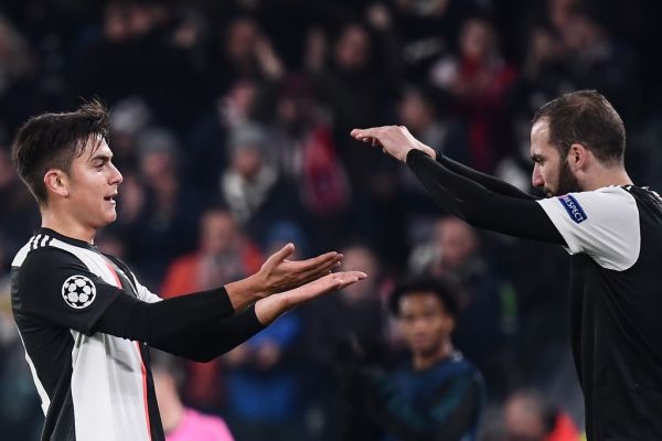 Juventus' Argentine forward Paulo Dybala (L) taps hands with Juventus' Argentinian forward Gonzalo Higuain to be substituted during the UEFA Champions League Group D football match Juventus Turin vs Atletico Madrid on November 26, 2019 at the Juventus Allianz stadium in Turin. PHOTO | AFP
