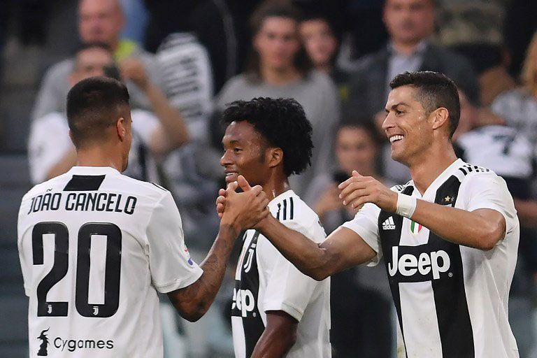 Juventus' Portuguese forward Cristiano Ronaldo (R) celebrates with Juventus' Portuguese defender Joao Cancelo (L) and Juventus' Colombian midfielder Juan Cuadrado after opening the scoring during the Italian Serie A football match Juventus vs Genoa on October 20, 2018 at the Juventus Allianz stadium in Turin. PHOTO/AFP