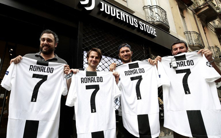 Juventus FC fans pose with the Cristiano Ronaldo number 7 shirt following the transfer of the five-time FIFA World Player of the Year to Turin last month. PHOTO/File
