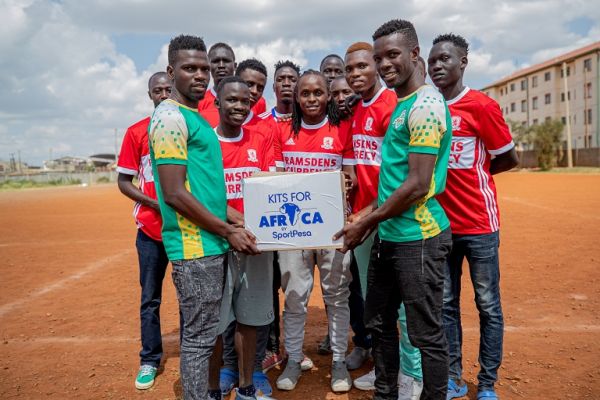 Kariobangi Sharks FC captain Eric Juma (right) and Patillah Omotto (left) present Kits For Africa donations to a team in the community. PHOTO | DUNCAN SIRMA | SPN