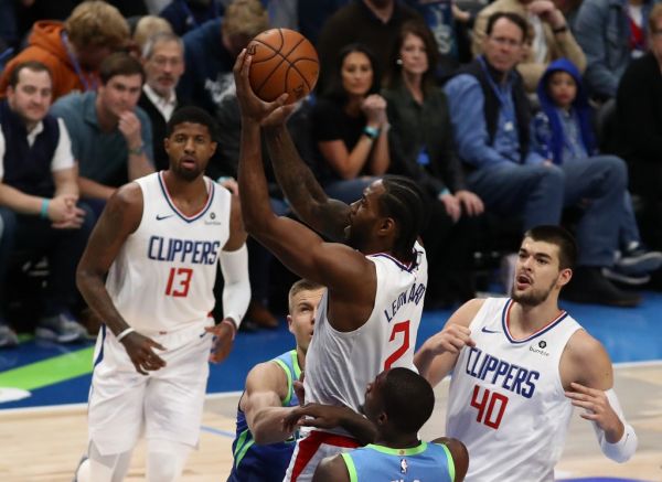 Kawhi Leonard #2 of the Los Angeles Clippers takes a shot against Kristaps Porzingis #6 and Dorian Finney-Smith #10 of the Dallas Mavericks at American Airlines Center on November 26, 2019 in Dallas, Texas. PHOTO | AFP