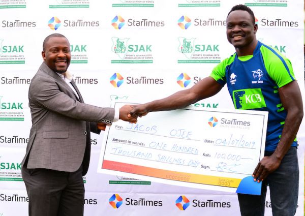 KCB RFC winger, Jacob Ojee (right) receives his KSh100,000 dummy cheque from Regional Director of Marketing, StarTimes Aldrine Nsubuga during the presentation ceremony of Sports Personality of the Month for May in Nairobi on Thursday, July 4, 2019. PHOTO/Courtesy